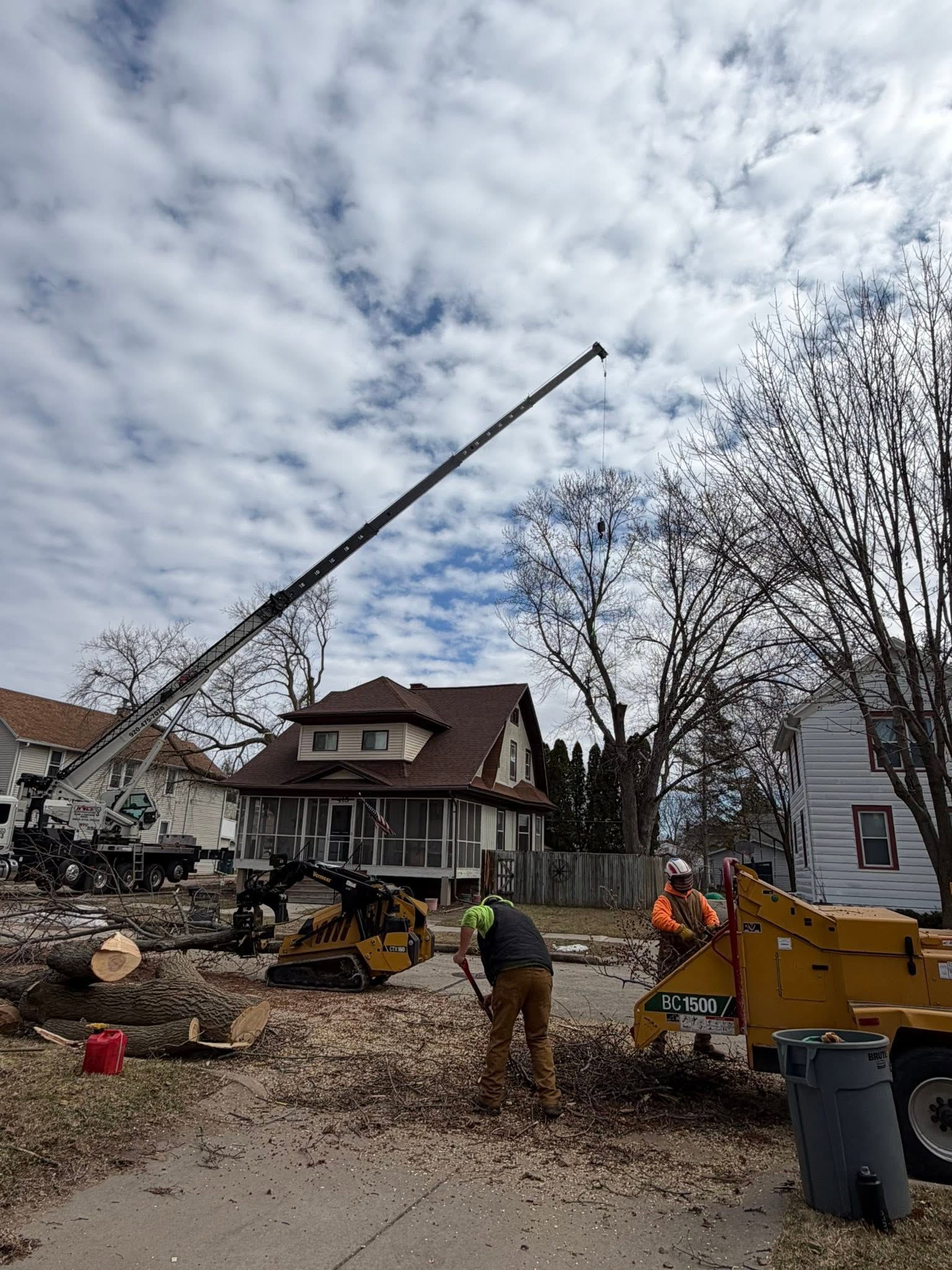 Crane and crew cleaning up a tree removal